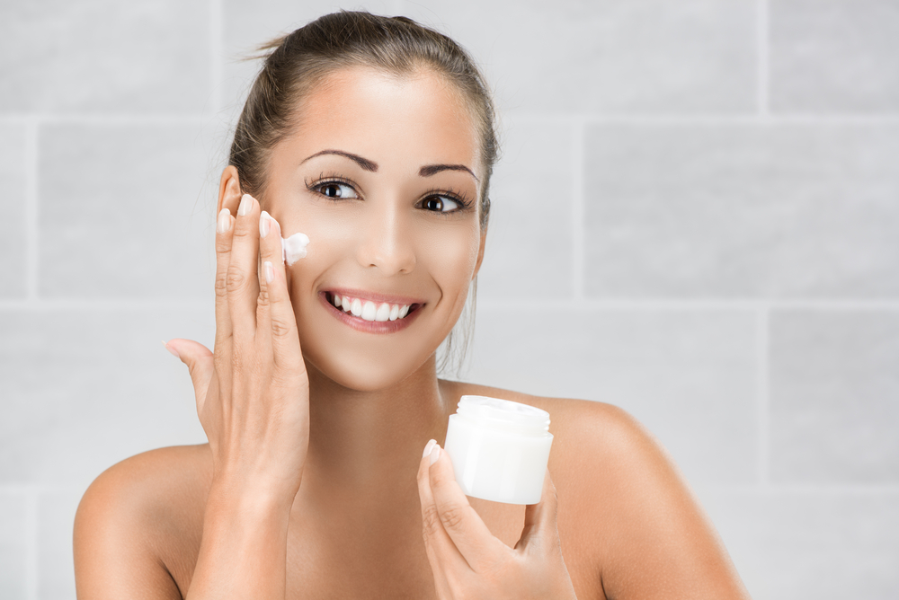 Woman massaging skin cream into her face.